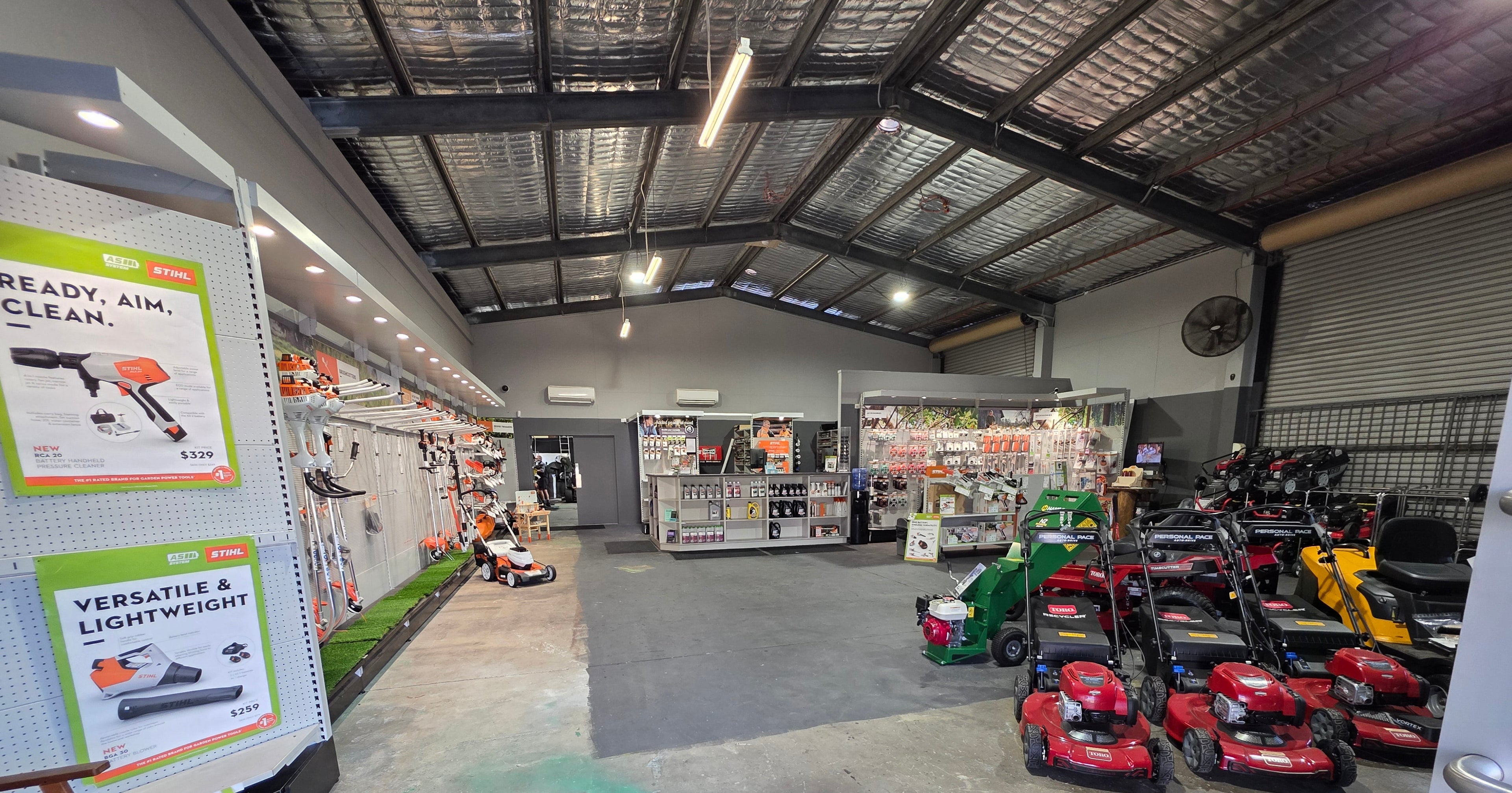 Inside Ipswich Mower and Saw Service with lawn mowers and gardening equipment displayed in a store.