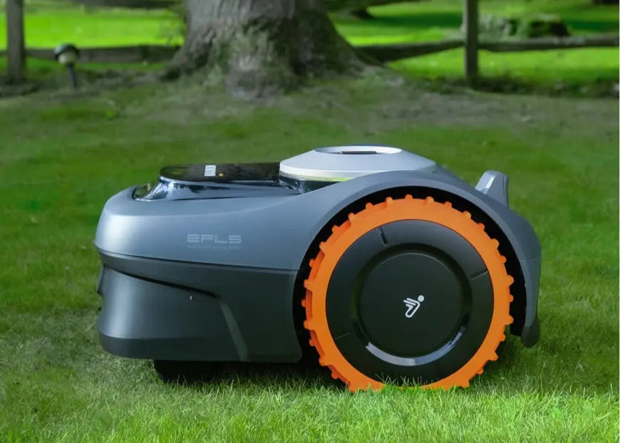 Picture of a Navimow i108 side on green grass and a tree trunk in the back ground